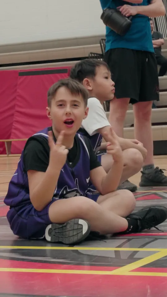 A young player laughing on the gym floor
